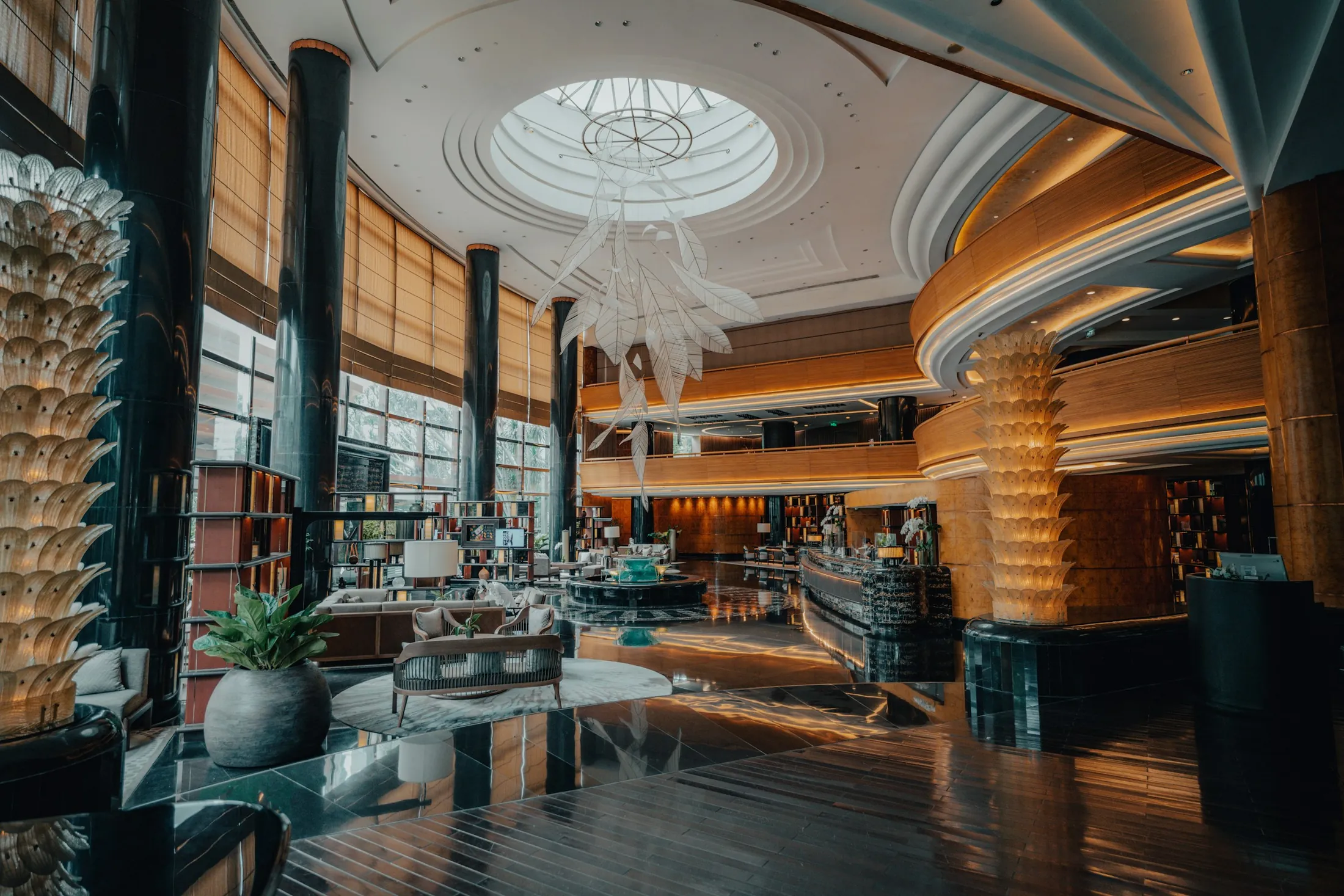 A grand hotel lobby with a domed ceiling and curved timber bar