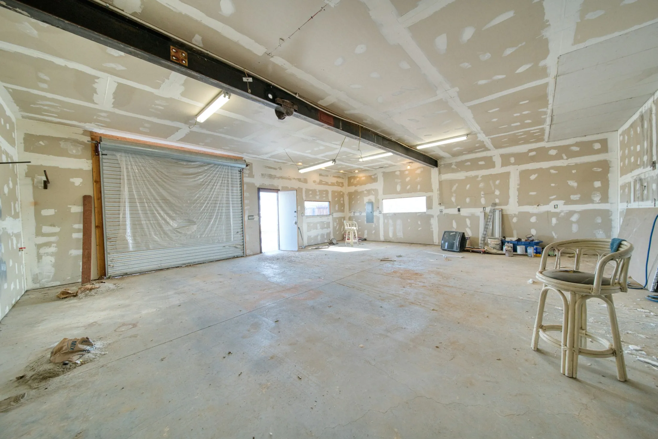 A large room with plasterboard walls awaiting finishing